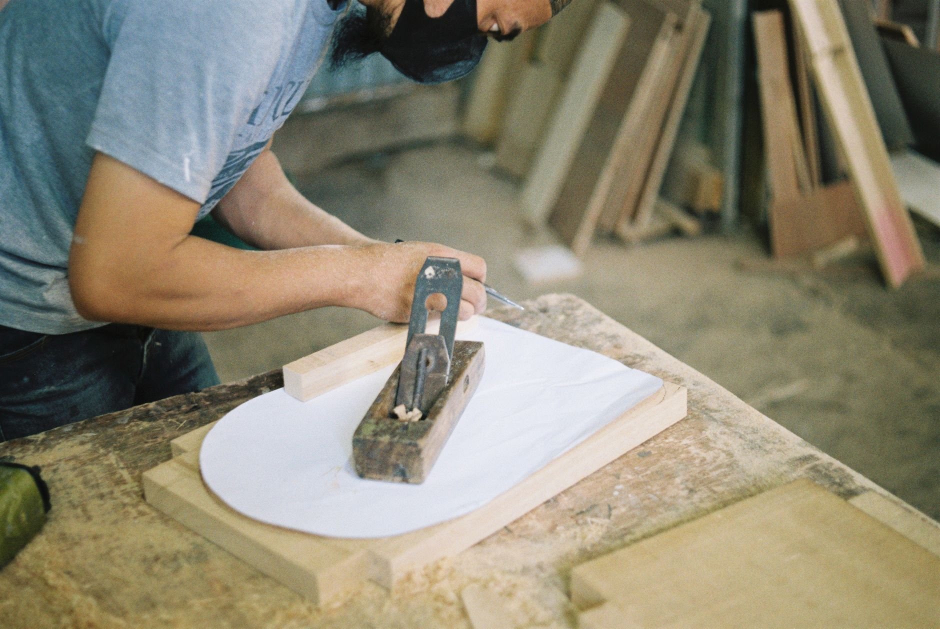 A carpenter working with a hand plane on a wooden surface during a construction training session